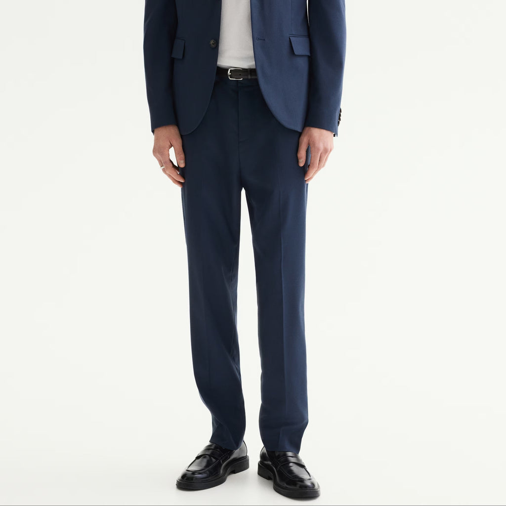 Man wearing a navy blue suit with a white shirt on a white background