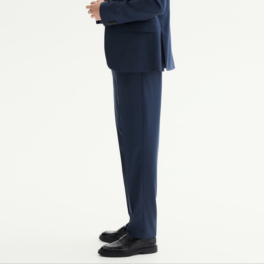 Man wearing a blue suit standing against a white background