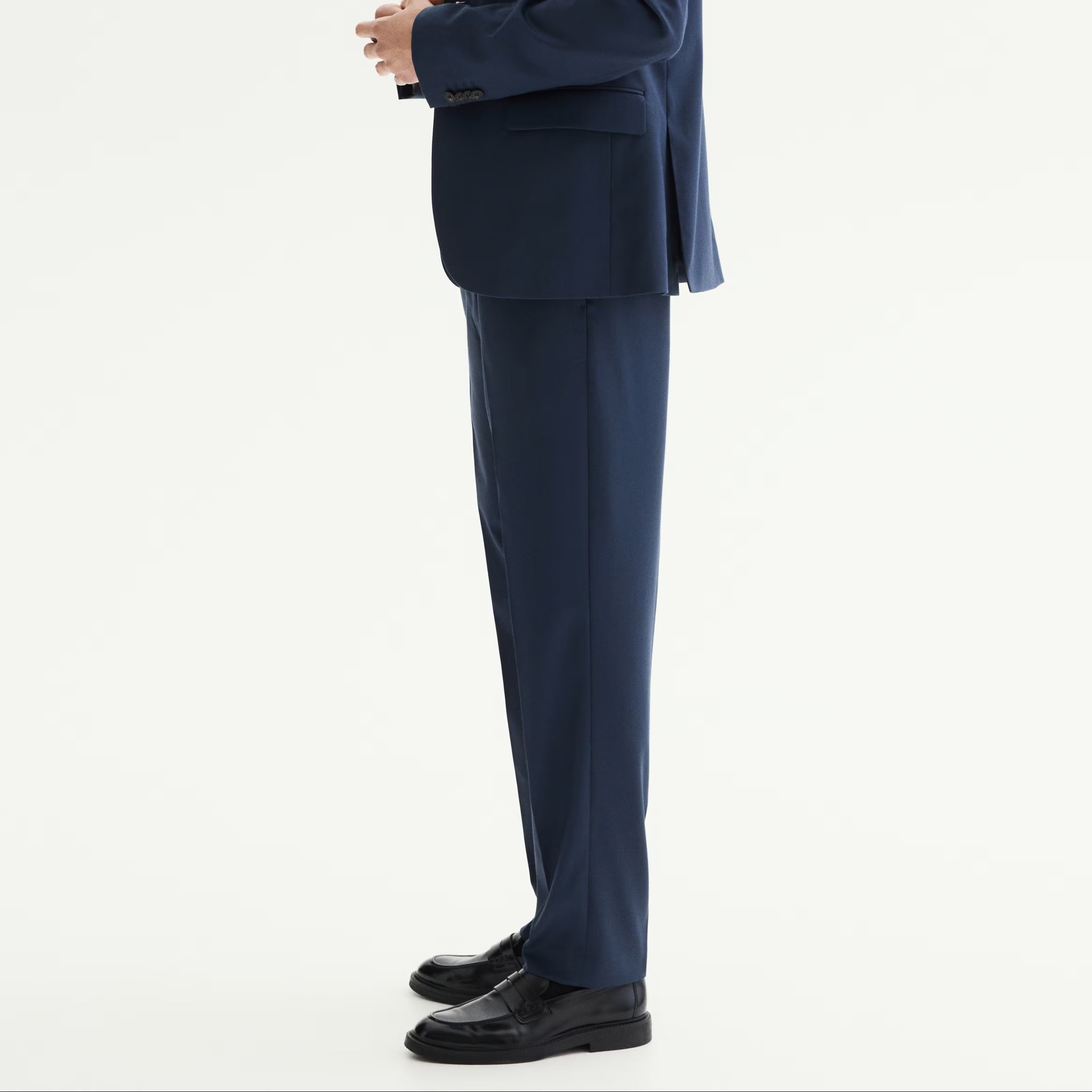 Man wearing a blue suit standing against a white background