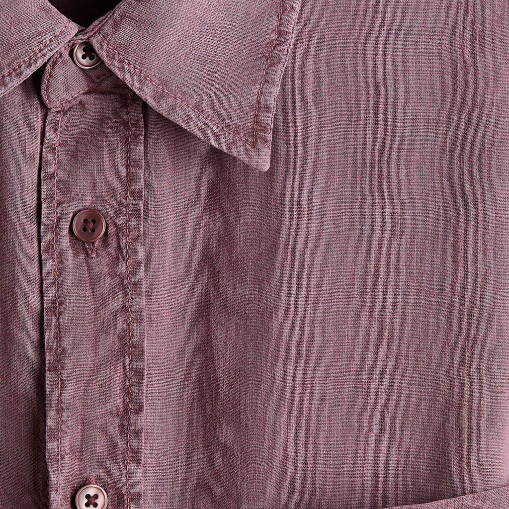 Close-up of a dusty mauve button-down shirt showing the collar, front buttons, and a chest pocket.