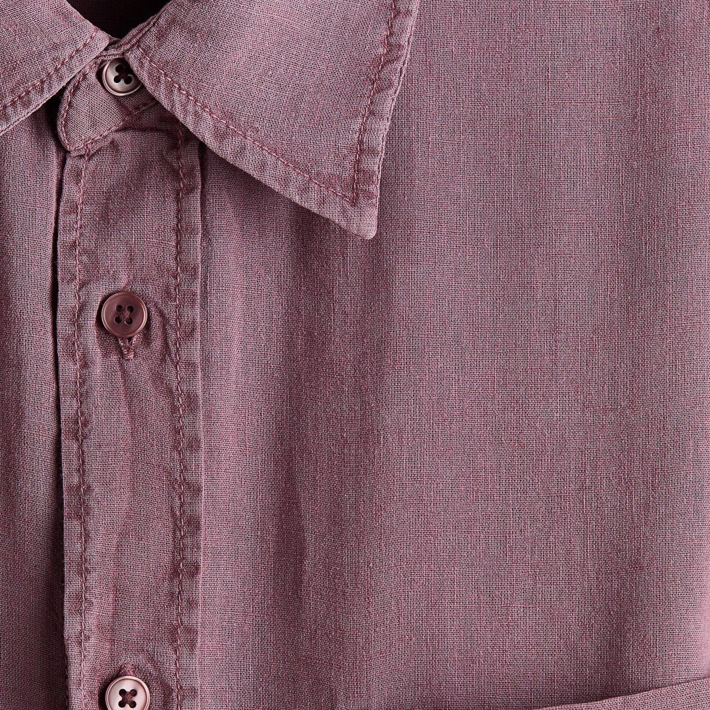 Close-up of a dusty mauve button-down shirt showing the collar, front buttons, and a chest pocket.