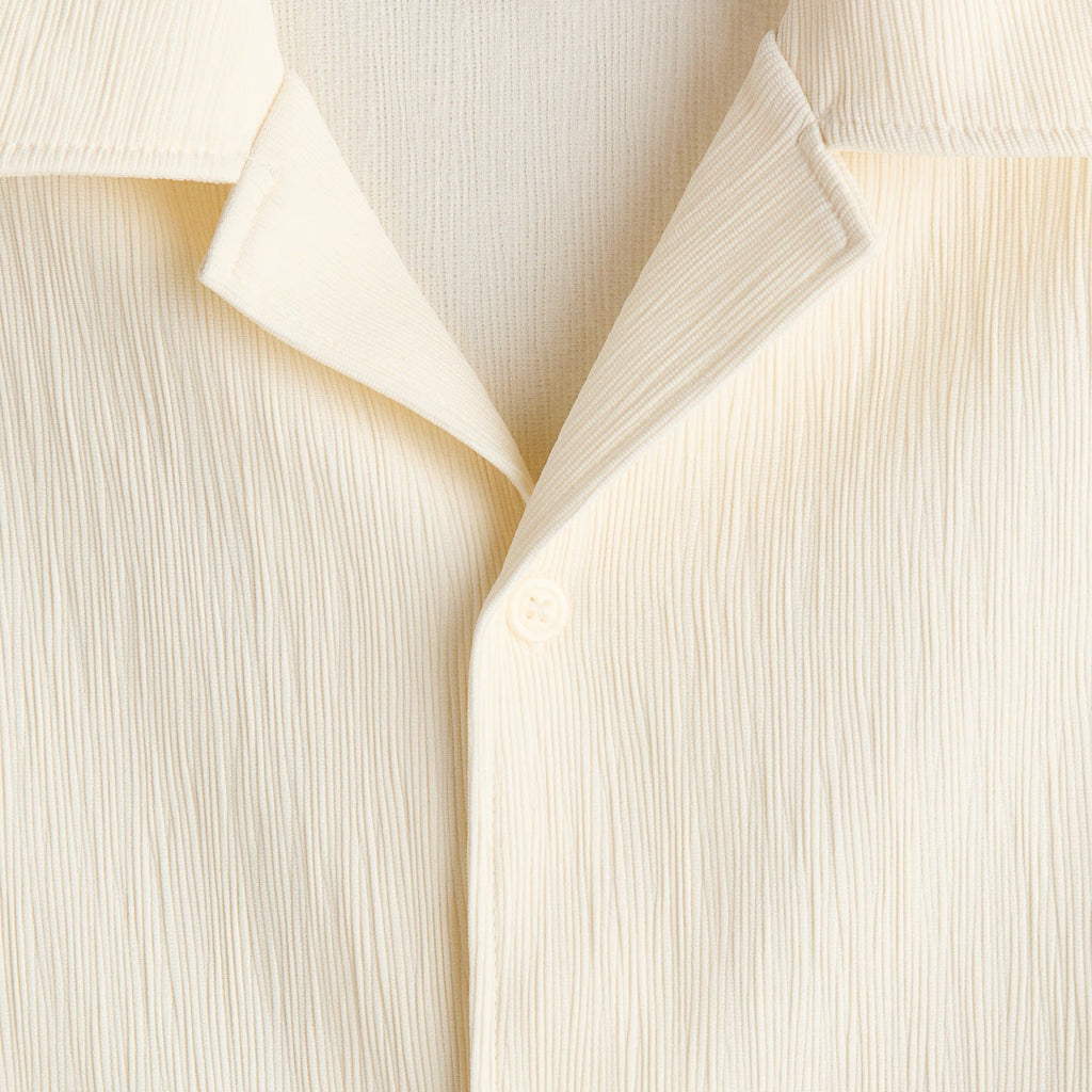 Close-up of a cream-colored crinkled fabric shirt showing the collar and button placket.
